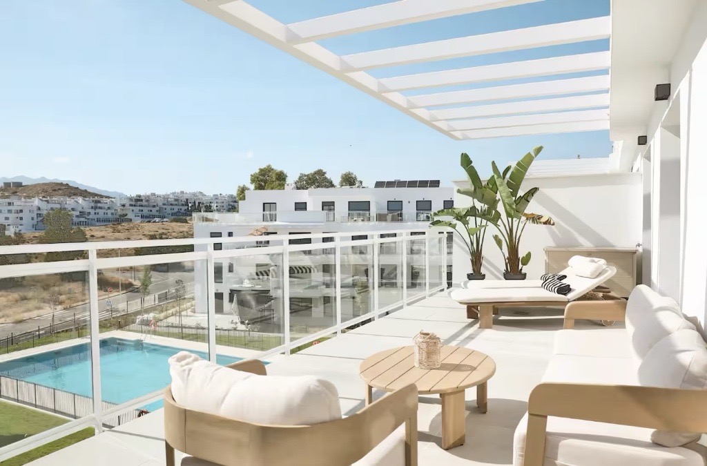 Ruim terras met loungemeubilair en uitzicht op het zwembad en de bergen