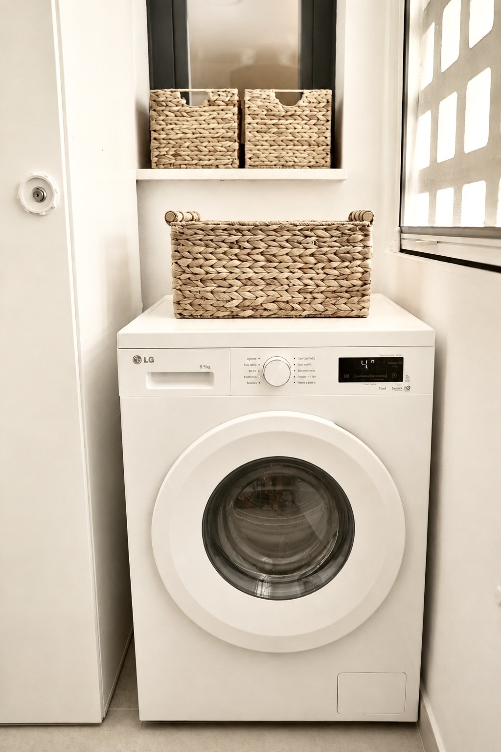 Wasruimte met wasmachine en manden