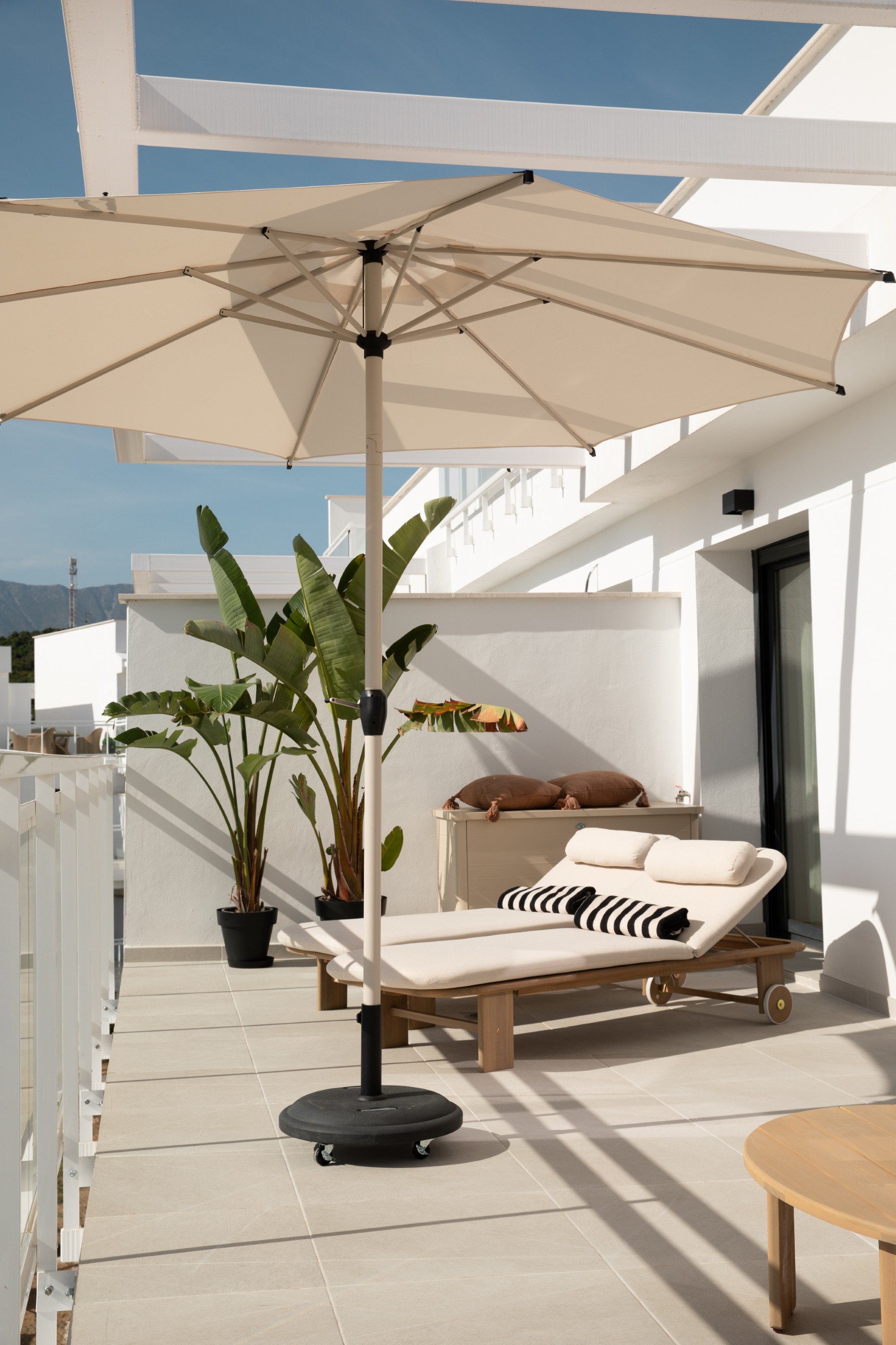 Dakterras met ligbedden, parasol en uitzicht op de bergen